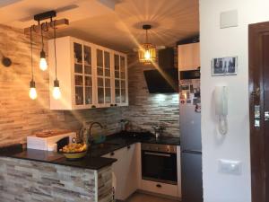 a kitchen with a refrigerator and a counter top at Guadarrama, ático nuevo con espectaculares vistas in Guadarrama