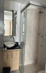 a bathroom with a glass shower with a sink at Hermoso loft en medellin in Medellín