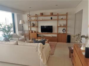 sala de estar con sofá blanco y TV de pantalla plana en Crazy Hit Tandil en Tandil