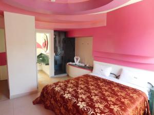 a bedroom with a large bed with a pink wall at Hotel Extasis in Mexico City
