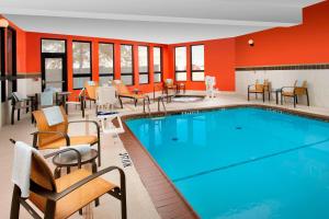 a pool in a hotel room with chairs and tables at Courtyard by Marriott Wichita Falls in Wichita Falls