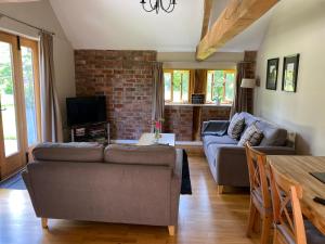 ein Wohnzimmer mit 2 Sofas und einem Tisch in der Unterkunft Hidden cottages in Henley in Arden
