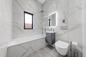 a white bathroom with a toilet and a sink at SERCASA - Appletree Court - Kingston in Kingston upon Thames