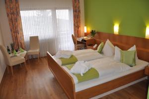 ein Schlafzimmer mit einem großen Bett mit weißer Bettwäsche in der Unterkunft Hotel-Restaurant Sonnenhof in Veitsrodt