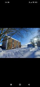 two pictures of a brick building in the snow at Whitehill Cottage in Castlewellan