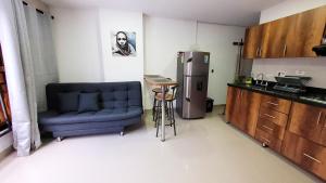 a kitchen with a blue couch and a refrigerator at ANDALIVING NIQUIA APARTAMENTO in Bello