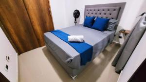 a bedroom with a bed with blue sheets and blue pillows at ANDALIVING NIQUIA APARTAMENTO in Bello