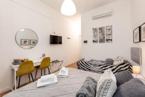 Un dormitorio con una cama, un escritorio y una mesa. en Julius Caesar Home, en Roma