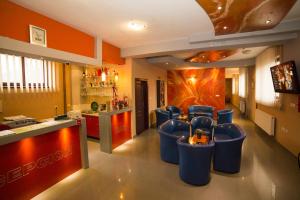 a kitchen with a bar with blue stools in it at B&B Vila Tamaris in Zaječar