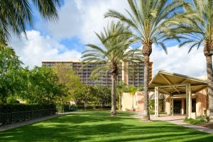 ein Gebäude mit Palmen vor einem Hof in der Unterkunft Sheraton Park Hotel at the Anaheim Resort in Anaheim
