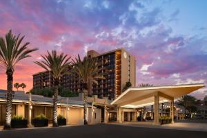 ein Hotel mit Palmen vor einem Gebäude in der Unterkunft Sheraton Park Hotel at the Anaheim Resort in Anaheim