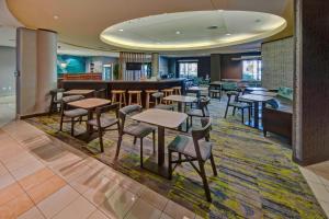 a restaurant with tables and chairs and a bar at SpringHill Suites by Marriott Naples in Naples