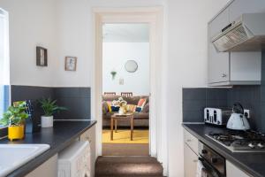 a kitchen with black countertops and a living room at Spacious 3 Bed Flat-Free Parking in Gateshead
