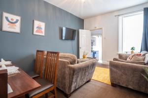 a living room with a couch and chairs and a table at Spacious 3 Bed Flat-Free Parking in Gateshead