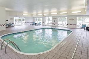 a large swimming pool in a room with chairs at Residence Inn Madison East in Madison