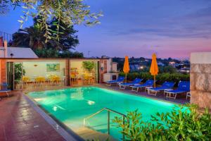 una piscina con sedie e tavolo di Hotel Villa Mena a Ischia