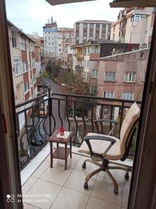 a room with a chair and a table on a balcony at 3+1 stylish furnished and spacious apartment in the center of Istanbul in Istanbul