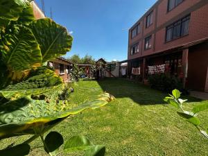 un patio con una gran planta arbolada junto a un edificio en Amplio departamento para 4 pers., en Cochabamba