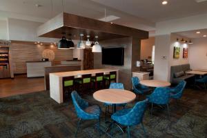hol z 2 stołami i krzesłami oraz bar w obiekcie Fairfield Inn & Suites by Marriott Spokane Valley w mieście Spokane Valley