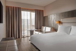 a hotel room with a bed and a chair and a window at AC Hotel by Marriott Manchester City Centre in Manchester