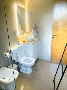 ein Badezimmer mit einem weißen WC und einem Waschbecken in der Unterkunft Casa Champagnat in Mendoza