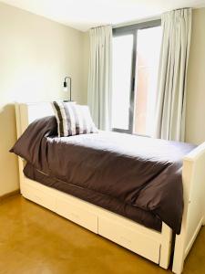 una cama en un dormitorio con ventana en Casa Champagnat, en Mendoza