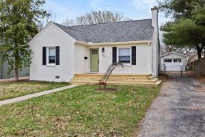 a white house with a porch and a yard at Isla's Landing in Lexington