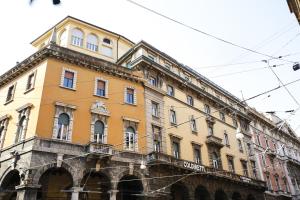 a large yellow building with a balcony at Albergo Garisenda con terrazza panoramica sulle Due Torri in Bologna