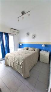 1 dormitorio con cama y pared azul en Departamento 2 ambientes en zona Güemes con balcón a la calle a 1 cuadra del Mar en Mar del Plata