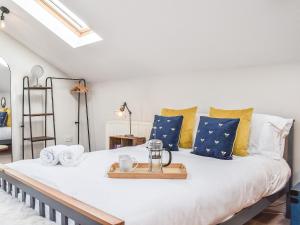 a bedroom with a large bed with blue and yellow pillows at Elm House Studio in Christleton