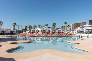 a large swimming pool with chairs and palm trees at Beautiful Room by WESTGATE Casino close to Las Vegas Convention Center in Las Vegas