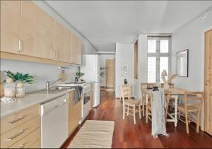 eine Küche mit weißen Schränken und ein Esszimmer mit einem Tisch in der Unterkunft Bergen city center apartment in Bergen