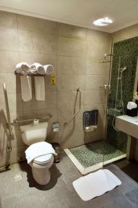 a bathroom with a toilet and a shower and a sink at Best Western Plus Fursan in Riyadh