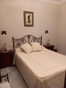 a bedroom with a large white bed with two night stands at Al ladito de Sevilla in Bormujos