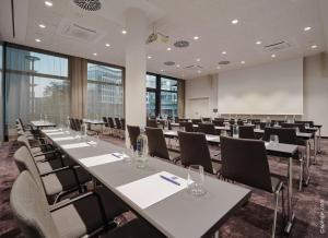 une salle de conférence avec des tables et des chaises et un tableau blanc dans l'établissement Dorint Hotel München/Garching, à Garching bei München