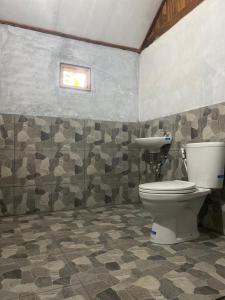 a bathroom with a toilet and a sink at Wina Wani Bungalows Tetebatu in Tetebatu