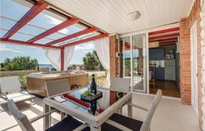a patio with a table and chairs and a kitchen at Amazing Home In Nerezine With Outdoor Swimming Pool in Nerezine