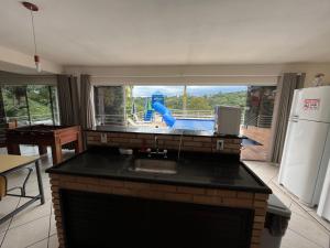 a kitchen with a sink and a playground in the background at Chácara em Mairinque - Porta do Sol com seg 24 hs in Mairinque