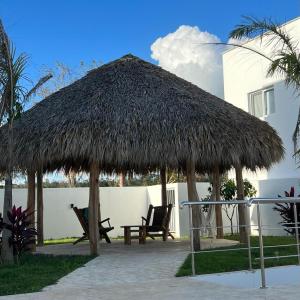 a large straw hut with chairs and a table at Villa Hermosa in Bayahibe
