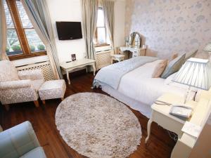 a bedroom with a bed and a chair and a tv at Customs House Country Inn in Belcoo