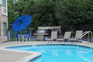 uma piscina com cadeiras e uma mesa com um guarda-sol em TownePlace Suites Wilmington Newark / Christiana em Newark