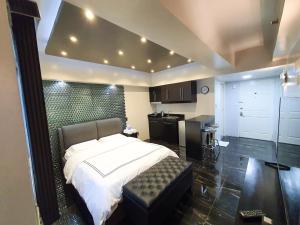 a bedroom with a large bed and a kitchen at Burgundy McKinley Place Service Apartment in Manila