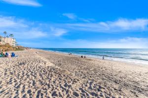 a beach with people sitting on the sand and the ocean at 3009 Ocean Street in Carlsbad