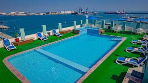 a swimming pool with chairs and a view of the water at Hotel Mar y Tierra in Veracruz