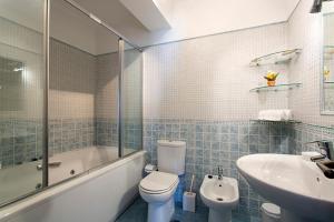 a bathroom with a toilet and a tub and a sink at By the Beach Duplex Apartment, Armacao de Pera, Algarve - Portugal in Armação de Pêra +21 photos