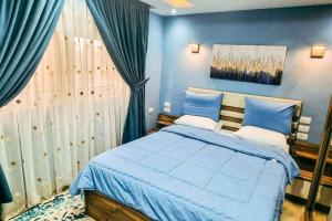 a blue bedroom with a bed and a window at Luxury VIP apartment in Cairo