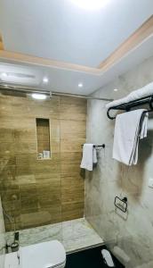 a bathroom with a shower and a toilet and towels at Luxury VIP apartment in Cairo