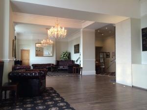 a living room with couches and a chandelier at Kensington Hotel in Llandudno