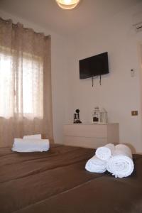 una camera con due asciugamani su un letto con televisore di Dolphin House a Pompei