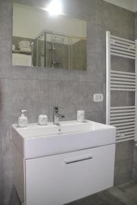 un bagno con un lavandino bianco e uno specchio di Dolphin House a Pompei Altre 13 foto